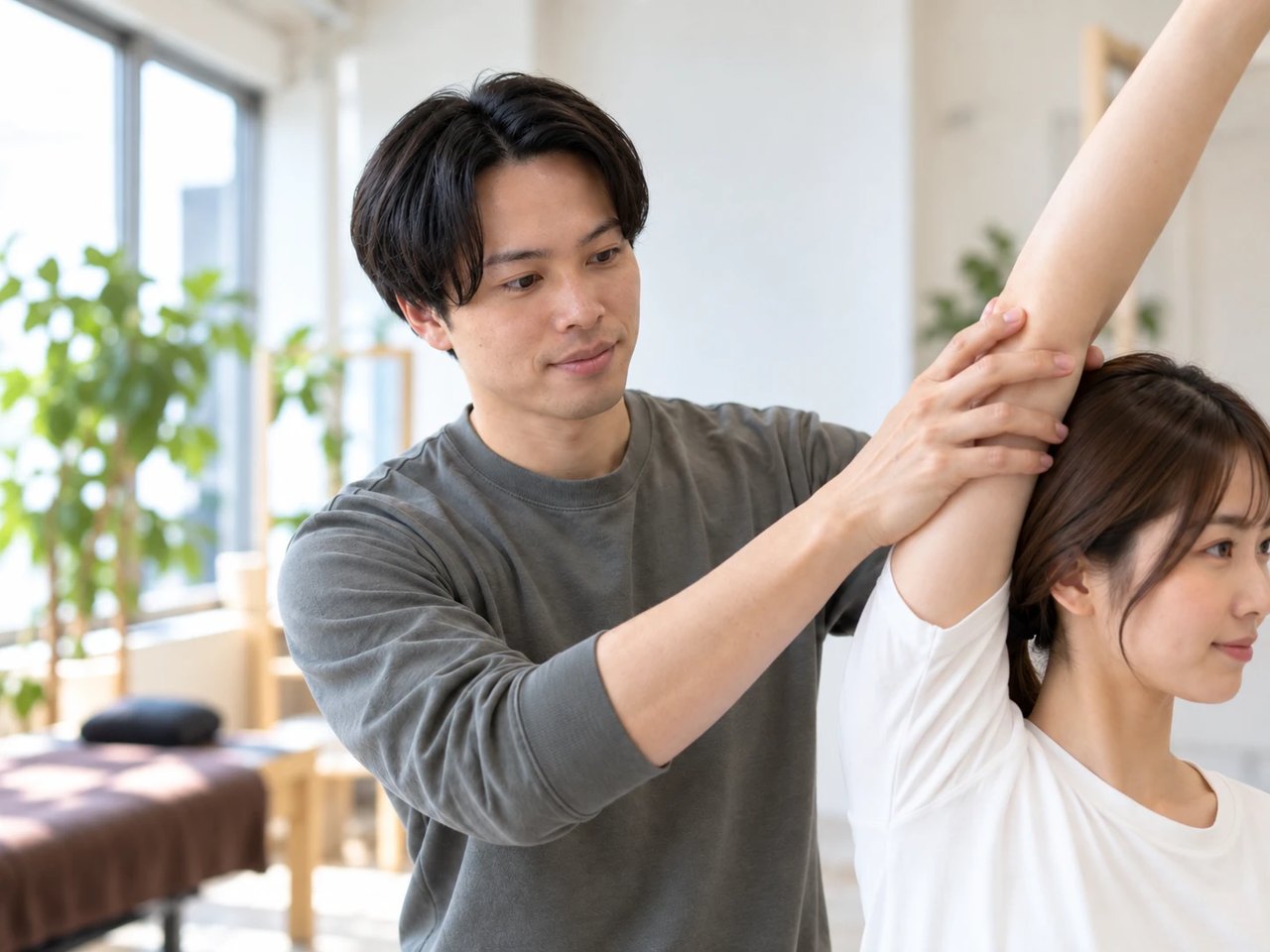 腕を支えながら、腕を上げる動きを確認する施術のイメージ